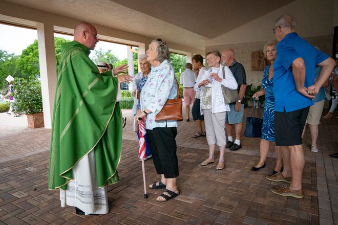 Rev. Tomasz Zalewsk talks with parishioners after church services, Saturday, June 26, 2021, at St. John the Evangelist in Naples.
