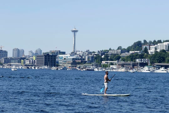 A person is surfing in Lake Union during a heat wave that swept the Pacific Northwest on Sunday, June 27, 2021 in Seattle, yesterday setting a record high for the day.  Record levels are expected today and Monday (AP/John Froschauer photo).