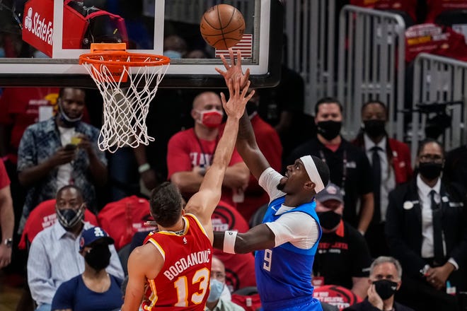 Bobby Portis of the Milwaukee Bucks scores a basket over Atlanta Hawks guard Bogdan Bogdanovic in the first quarter during Game 3 of the Eastern Conference Finals on Sunday, June 27, 2021, at State Farm Arena. Portis scored 15 points on 7-of-12 shooting off the bench.