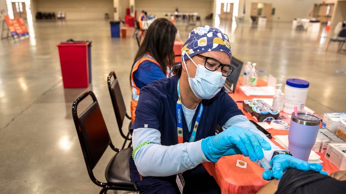 Nurse Tony Saldana administers a COVID-19 vaccine inside the Curative operated site at the Indio Fairgrounds in Indio, Calif., on June 28, 2021. 