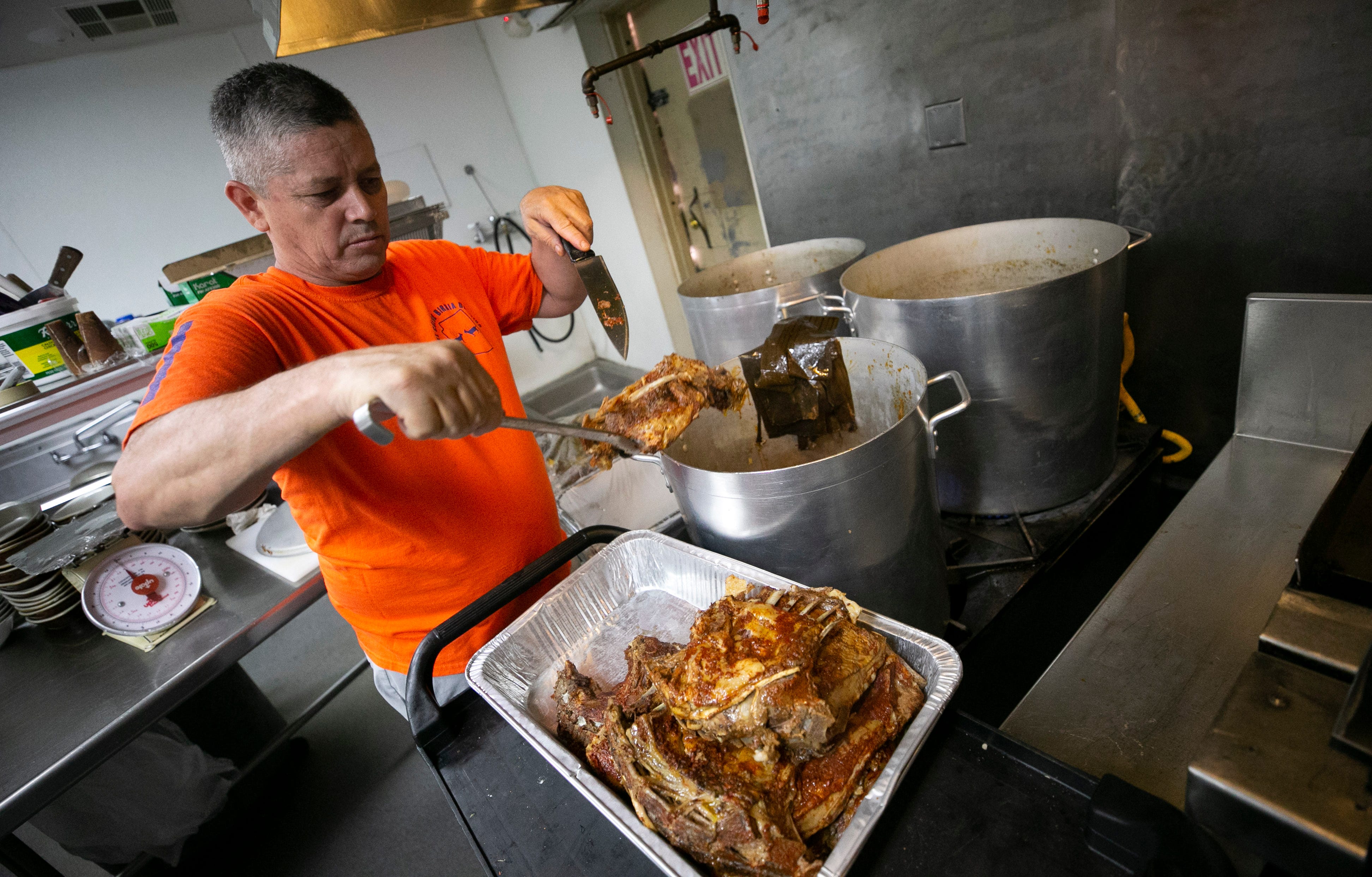 Jose Luis Garcia, owner and chef, takes birria (stewed goat meat) out of a pot after cooking all night at El Güero Birria de Chivo restaurant in south Phoenix on June 18, 2021.