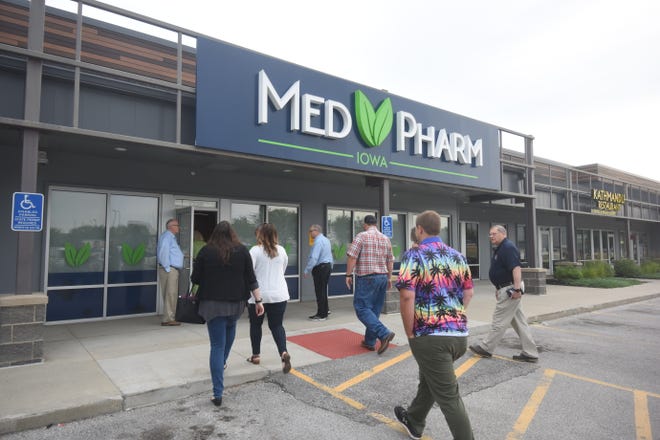 Rep. Ernie Otten, R-Tea, holds the door at the entrance to Med Pharm Iowa Monday, June 28, for participants of a medical marijuana facilities tour in Des Moines.