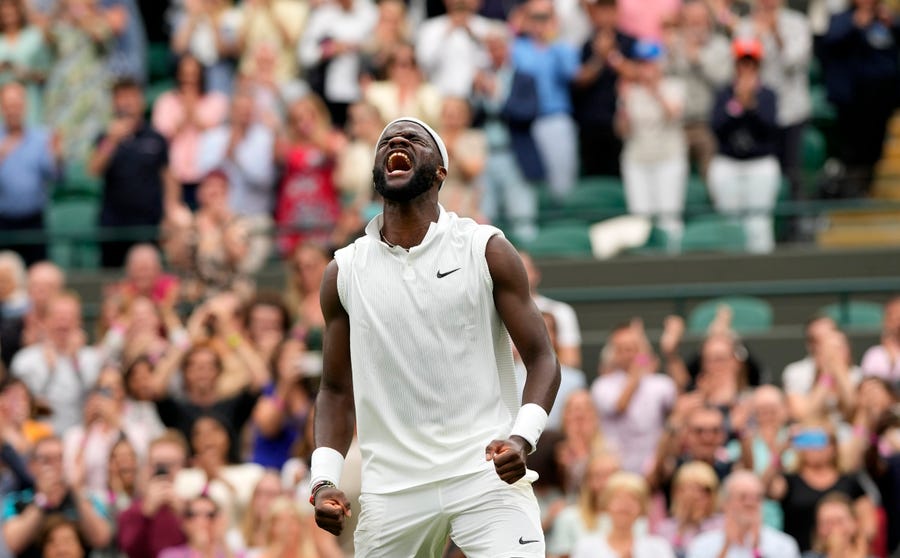Frances Tiafoe of the US celebrates after winning the men's singles match against Stefanos Tsitsipas of Greece on day one of the Wimbledon Tennis Championships in London, Monday June 28, 2021.