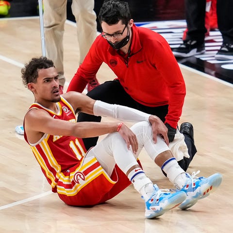 Trae Young is attended to after injuring his ankle