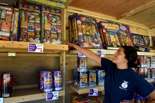 Veronica Lemus, an agriculture teacher and advisor for Fillmore Future Farmers of America, points out some of the most popular fireworks packs June 28 that were sold in Fillmore, the only city in the county where they are allowed.