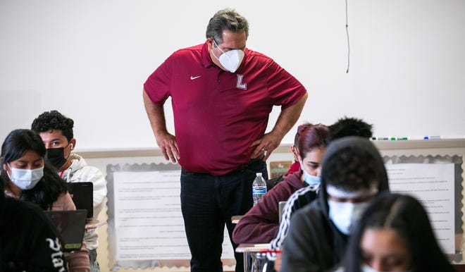 Palm Beach Lakes High School Principal David Alfonso looks over a student's shoulder during summer school Wednesday.