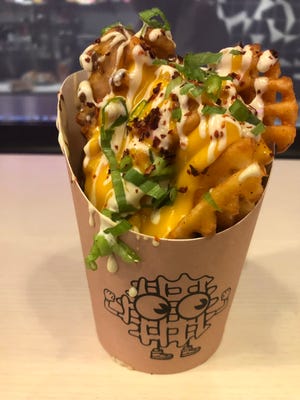 Dirty-dipped waffle fries at Mister Dips are drizzled with queso, Hatch chili mayo and sprinkled with scallions and Aleppo pepper.