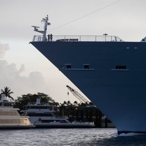 Passengers stand on the bow of the Royal Caribbean