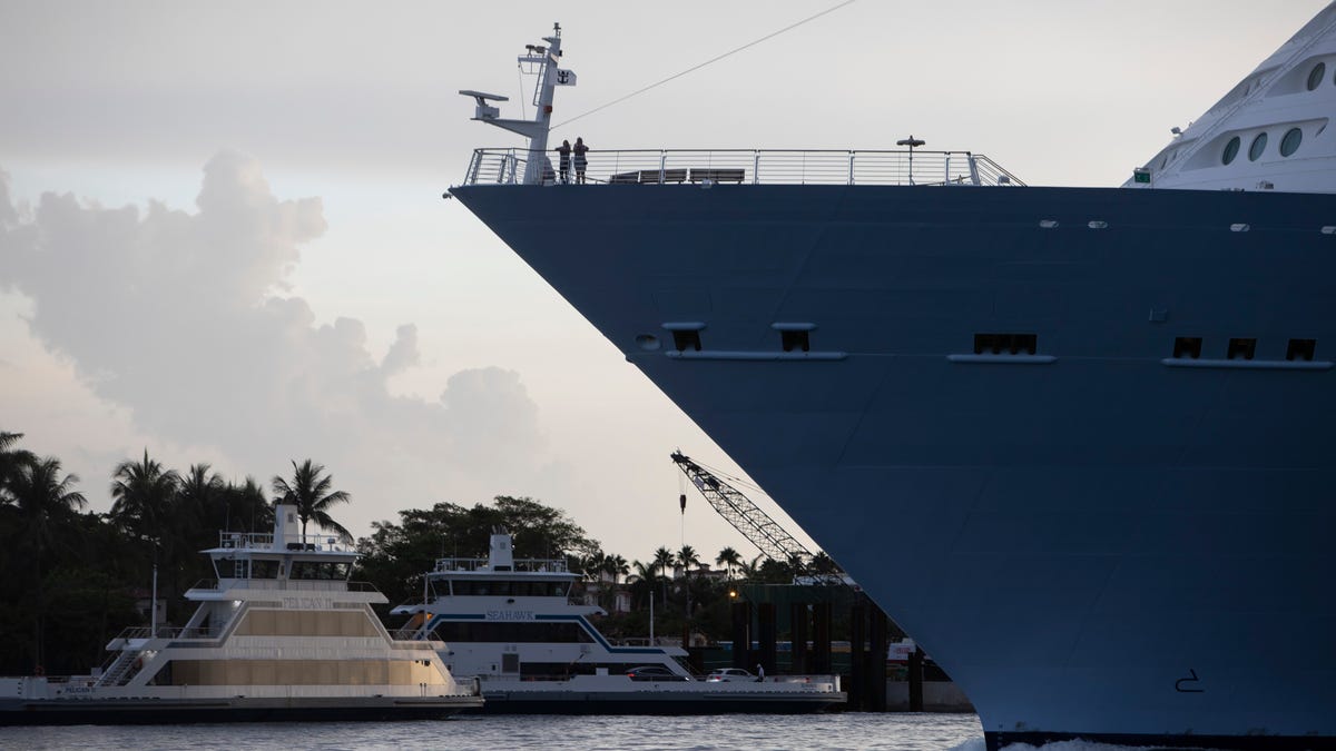 Passengers stand on the bow of the Royal Caribbean Freedom of the Seas as it gets underway through the Government Cut shipping channel at PortMiami during the first U.S. trial cruise testing COVID-19 protocols on June 20, 2021 in Miami, Florida.