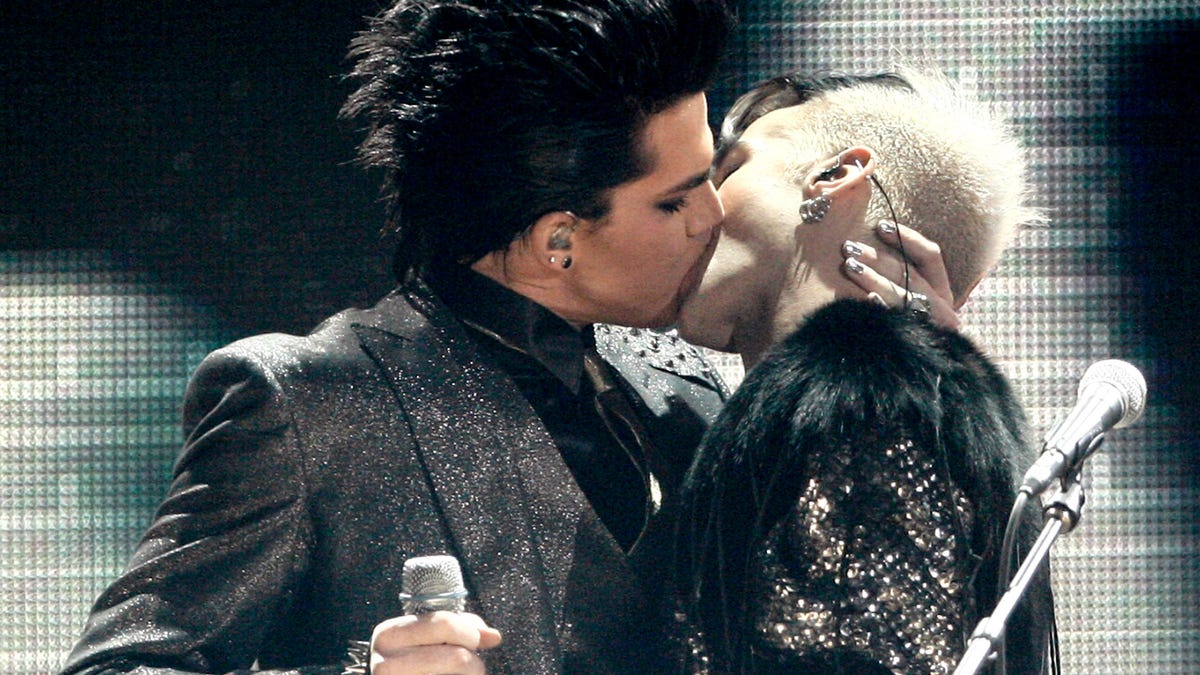 Adam Lambert, left, kisses one of the dancers as he performs during the closing act of the 37th Annual American Music Awards on Sunday, Nov. 22, 2009, in Los Angeles. (AP Photo/Matt Sayles) ORG XMIT: CADC229