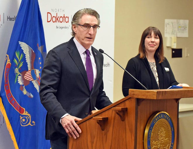 Molly Howell, immunization program manager for the North Dakota Department of Health, listens as Gov. Doug Burgum talks about the COVID-19 pandemic during a press conference on March 20, 2020, in Bismarck, N.D.