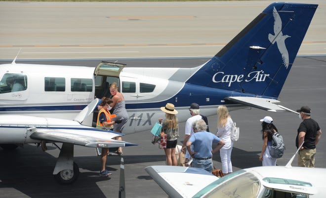 Passengers line up for a full Cape Air flight to Nantucket from Hyannis last year on one of the company's current standard planes. In a few years, it hopes to have a fleet of all-electric commuter planes.