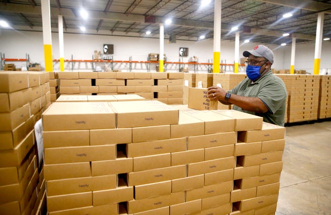Dee Clark, warehouse manager, shows a Datebox at the Happily warehouse at 1398 Metropolitan Ave. Happily is an online subscription service that designs, fills, sorts and distributes boxes of items designed to provide a custom date night. "E-commerce and on-demand delivery service accounts for $4.2 billion or 5.5% of total GDP for the Oklahoma City metro today," CBRE reports.