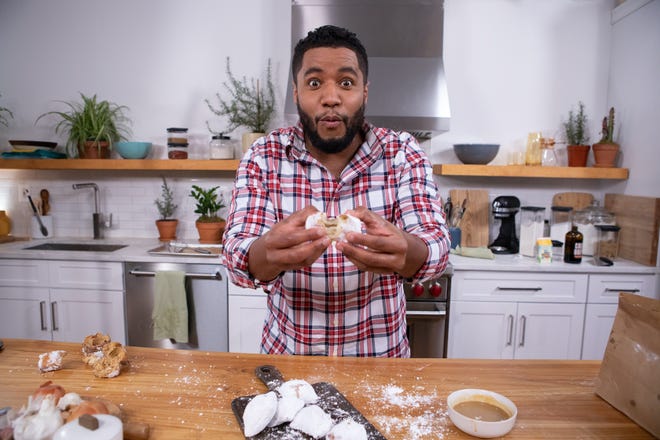 Bryan Ford stars in the new series "The Artisan's Kitchen" on the Magnolia Network. In this scene, the New Orleans raised baker holds up a beignet.