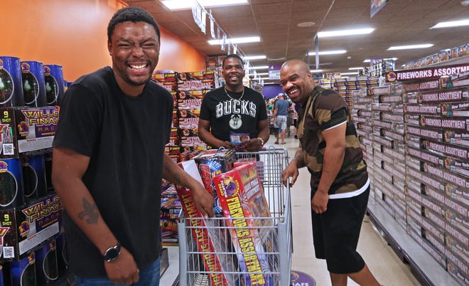 Terry Walters, left, Jonathon McCray, center, and Quamay Daniels, all from Kenosha, show off their fireworks purchases at Phantom Fireworks of Racine. They said lighting fireworks at their homes is a family tradition. They were also planning on going to Extreme Fireworks a few miles away.