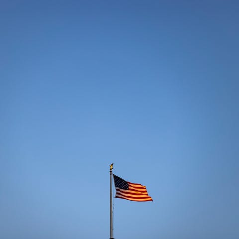 The setting sun illuminates the American flag flyi