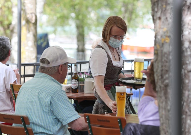 A waitress serves beer at a beer garden on May 10, the first day that outdoor restaurant seating reopened in some regions across Bavaria in Woerthsee, Germany. (Photo by Alexandra Beier/Getty Images)