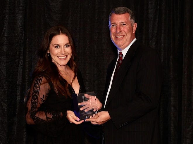 Madi Young accepts the Junior College Female of the Year award with Mike Sharp, Director of the Greater Wichita Area Sports Commission, at the Drury Hotel in Wichita, Kansas on Thursday, July 1.