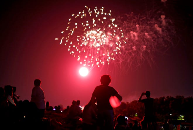 People watch the Fourth of July fireworks show at Freedom Fest at Chisholm Trail Park in Yukon, Okla., Saturday, July 3, 2021.