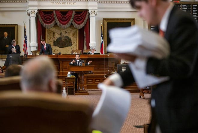 A staff member hands out papers while State Representative Diego Bernal, D-San Antonio, speaks in the plenary session during this year's regular session.