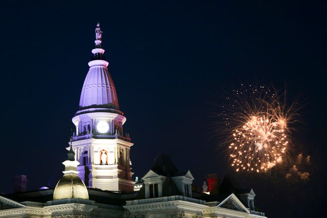 The Tippecanoe County Courthouse is illuminated as fireworks explode in the distance, Sunday, July 4, 2021 in Lafayette.