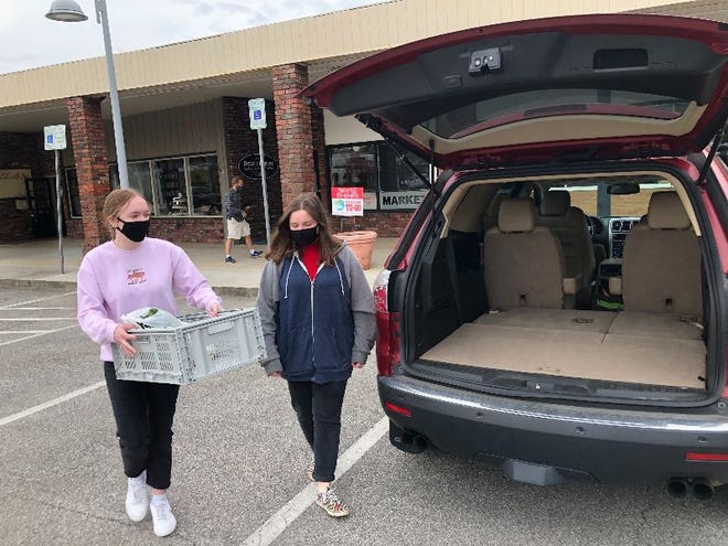 Market-To-Go workers deliver an online farmers' market order curbside on Saturday morning in Jackson Square, Oak Ridge. The market is moving to St. Mary's School for the winter.