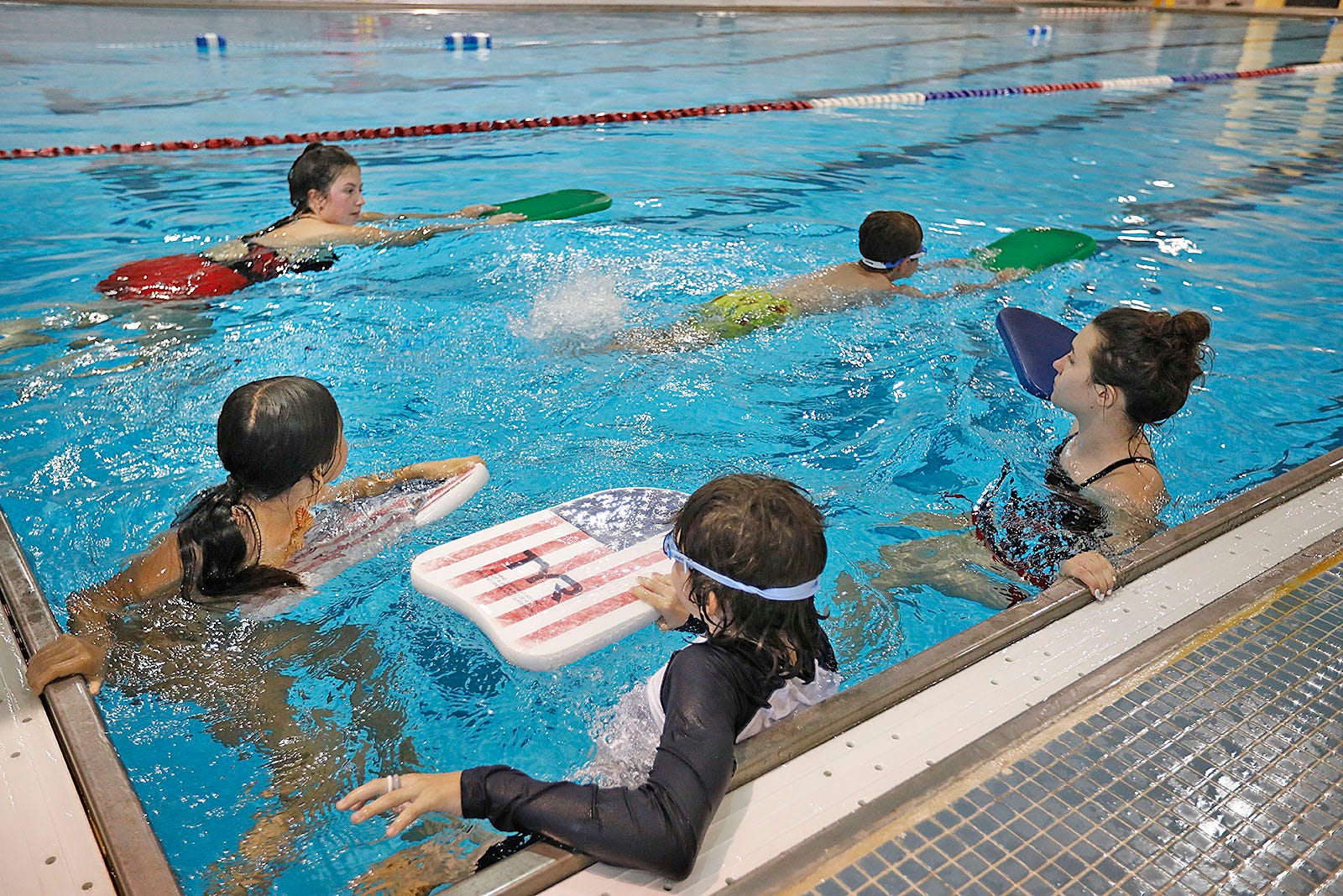 Swimming instructor demonstrating with kickboard