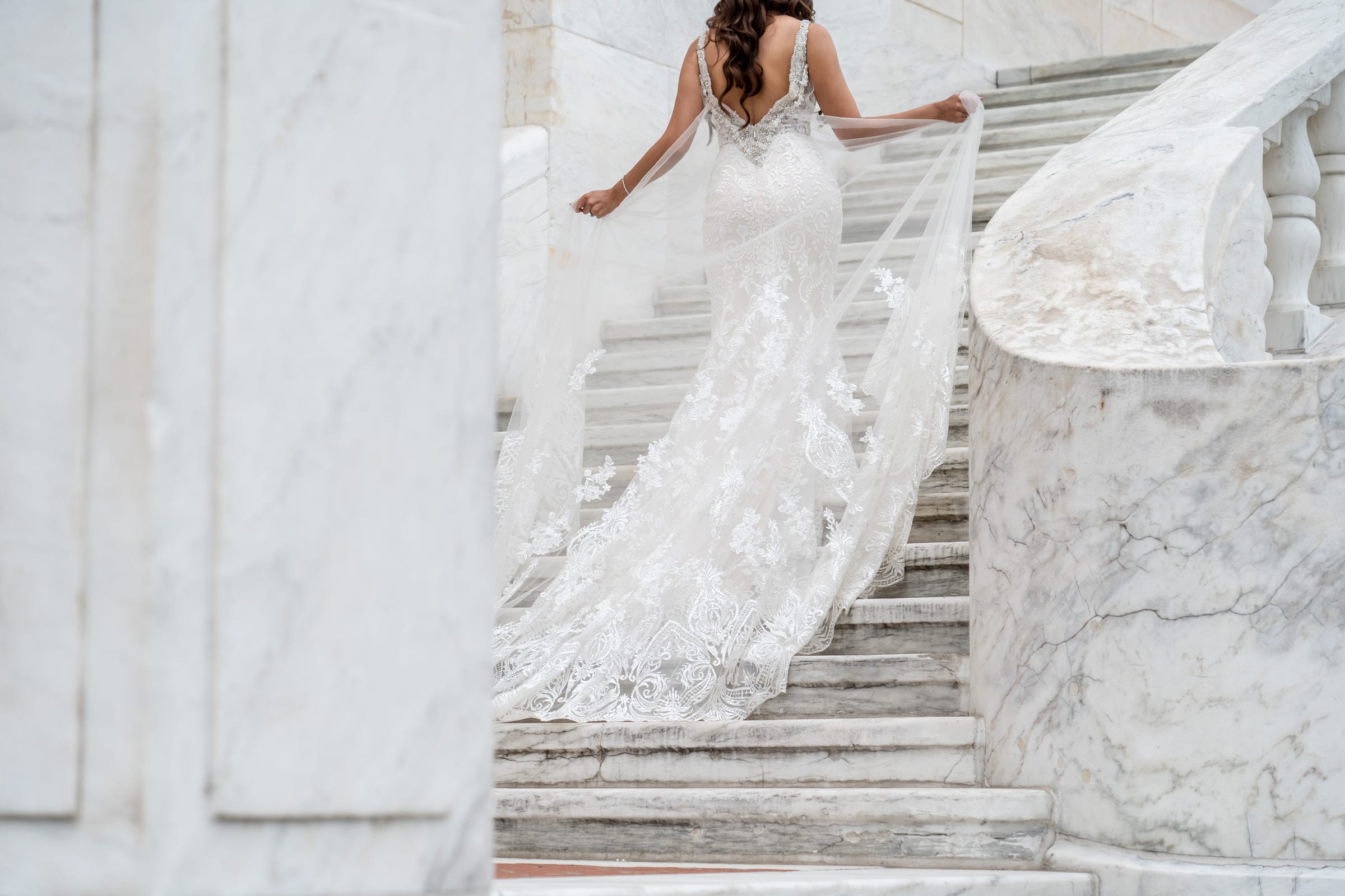 Shannon Wolfram of Lake Orion holds her dress while walking up the staircase at the rear of the Detroit Institute of Arts on Saturday, June 19, 2021 while having her photo taken on her wedding day.