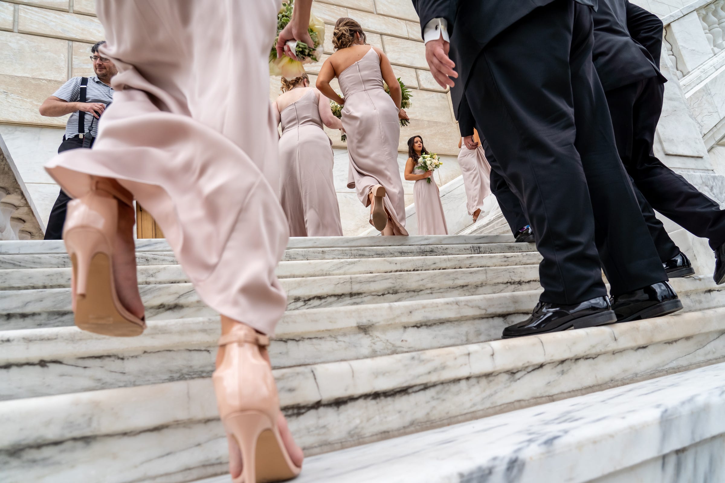 Photographer Arthur Safarov waits for a bridal party to get into position to take their photos on the staircase at the rear of the Detroit Institute of Arts on Saturday, June 19, 2021.
