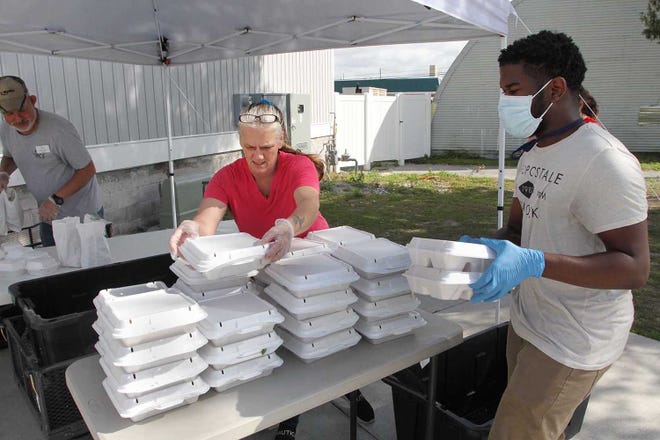 Religious Community Services staff Tony Laboy, Jeanette Pawelczyk and volunteer David Green help  distribute free lunch meals in March 2020.