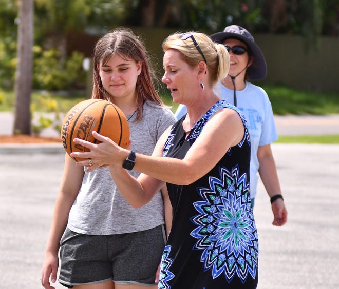 Program director Michele Ramsay works with Kira on her shooting skills on the basketball court.