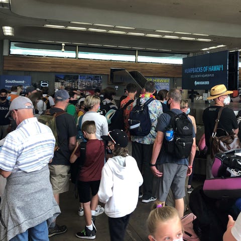 Passengers arriving in Maui wait for bags in the c