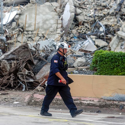 A first responder walks past debris from the implo