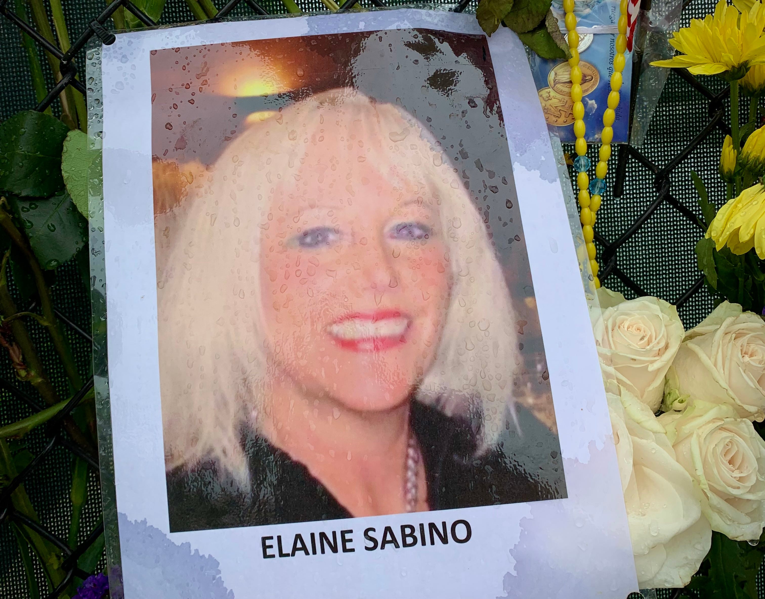 A photo of Elaine Sabino on the memorial wall near the site of the Champlain Towers South collapse. Sabino lived on the 12th floor with Richard Augustine. On July 7, after being listed as missing for two weeks, authorities notified her family that they had found her body.