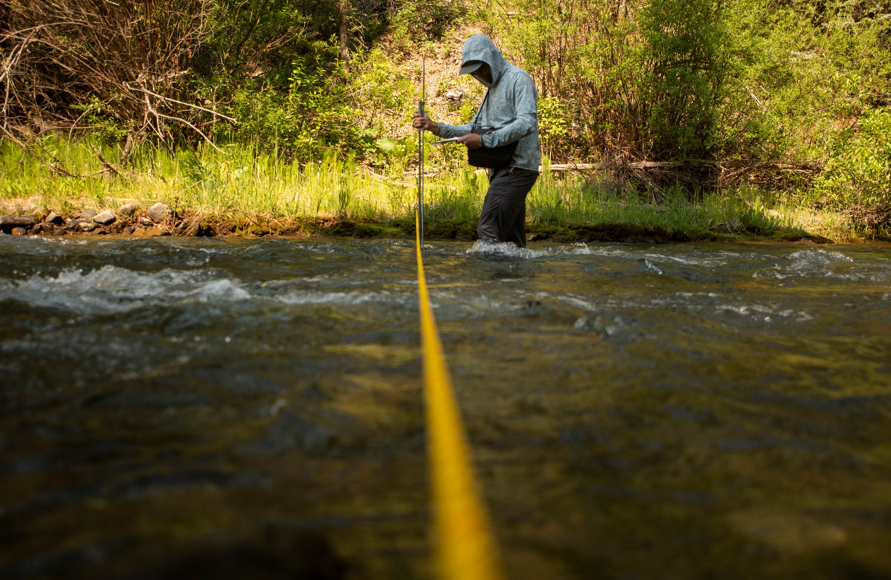 Adrian Bergere, interim program coordinator for the San Miguel Watershed Coalition, collects stream gauging data along the South Fork San Miguel River near Telluride, Colorado, on June 22, 2021.