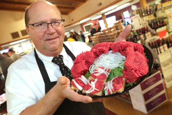 Ray's Butcher Shoppe co-owner Perry Podd holds up the cannibal sandwich, made from raw beef and onions on rye bread, at Ray's Butcher Shoppe in Greenfield. The shop has been around since 1977.