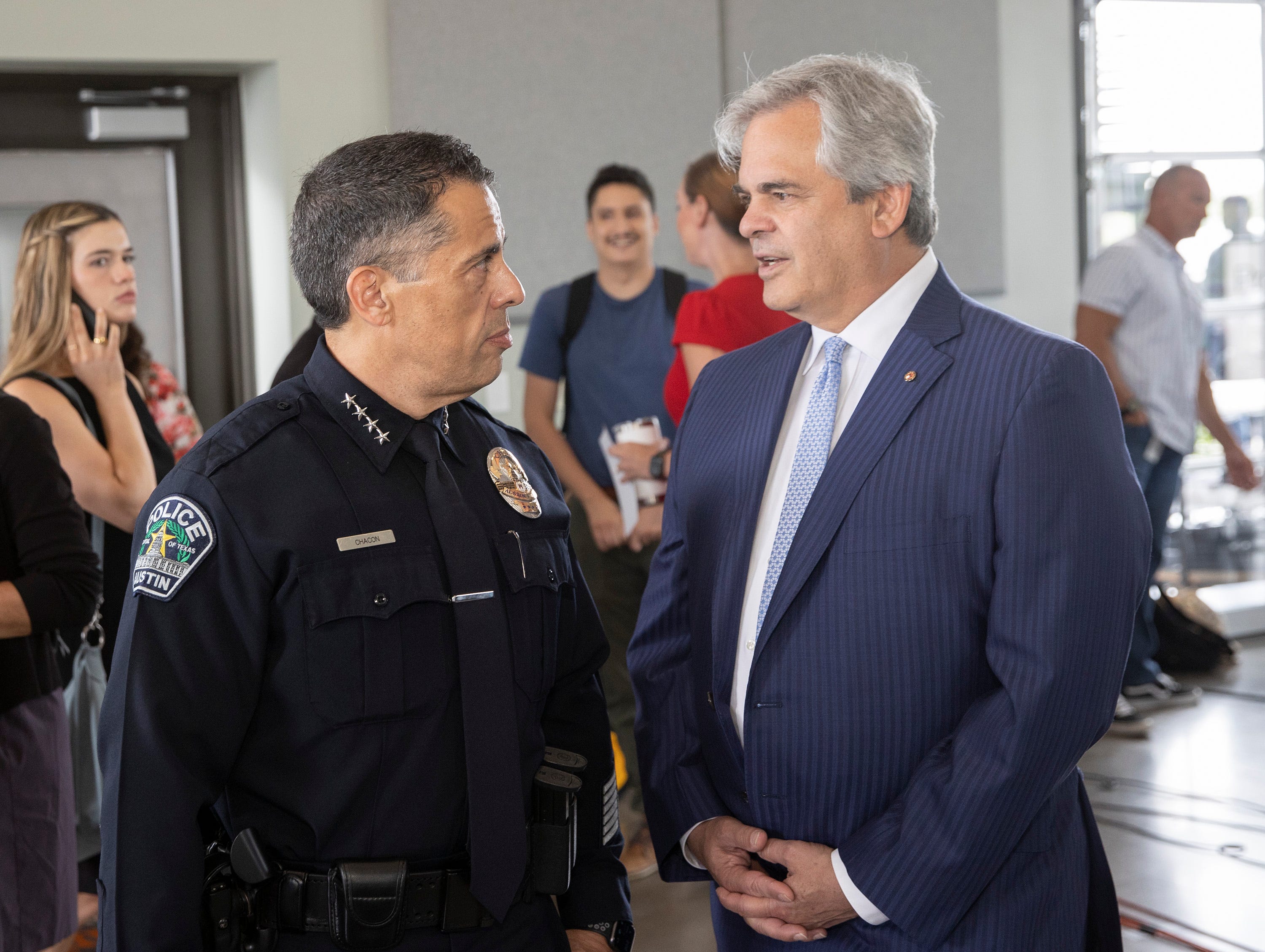 Interim Police Chief Joe Chacon talks to Mayor Steve Adler in July before City Manager Spencer Cronk presented a proposed 2021-22 budget. The 2020-21 budget cut funding for the Police Department, and city officials suspended three cadet classes in a row.