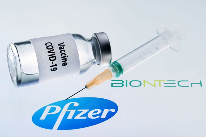 This illustration picture taken on Nov. 23, 2020 shows a bottle reading "Vaccine COVID-19" and a syringe next to the Pfizer and Biontech logo. Pfizer is now considering a third shot for the already vaccinated as a form of booster shot to shore up protection against the virus. (Joel Saget/AFP via Getty Images/TNS)