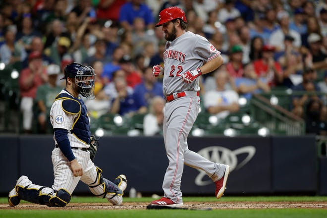 Reds starting pitcher Wade Miley crosses in front of Brewers catcher Manny Pina for a run in the seventh inning.