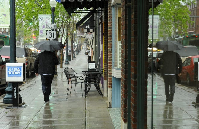 Shoppers use umbrellas as heavy rain fall on Main Street in downtown Franklin. File photo from 2013.