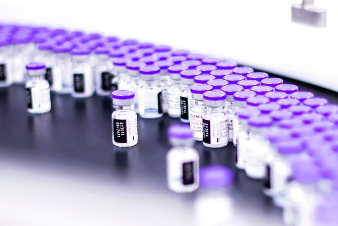 In this March 2021 photo provided by Pfizer, vials of the Pfizer-BioNTech COVID-19 vaccine are prepared for packaging at the company's facility in Puurs, Belgium.
