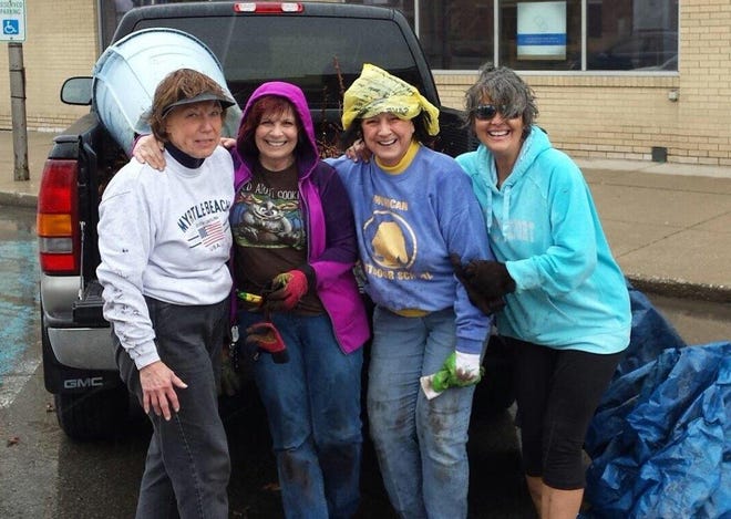 This spirited quartet, members of the Earth, Wind and Flowers Garden Club, was captured at the end of a work session on the city square.
Drenched by rainfall yet full of laughter the team was photographed by a passing motorist.
L - R: Dianna Zaebst, Shirley Chapman, Mary Lee Minor (in a shopping bag rain hat) and Susan Maynard.