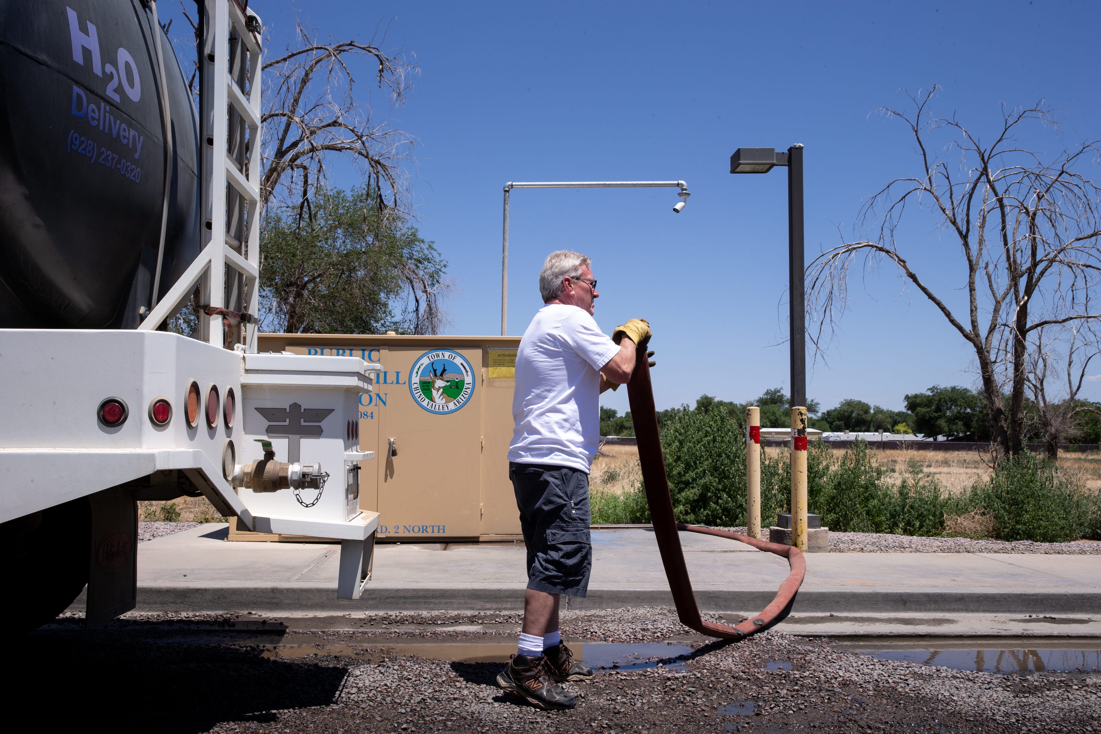 Lyle Gibbs winds up the hose after filling his H2O Delivery truck at the Public Water Fill Station, July 8, 2021, at 480 West Road 2 North, Chino Valley, Arizona.