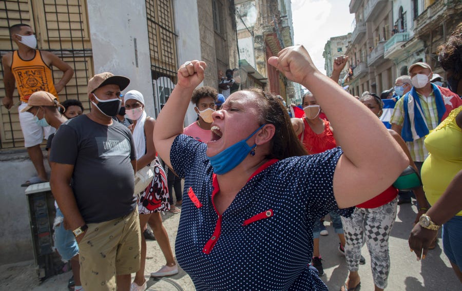 A woman shouts pro-government slogans as anti-government protesters march in Havana, Cuba, Sunday, July 11, 2021. Hundreds of demonstrators took to the streets in several cities in Cuba to protest against ongoing food shortages and high prices of foodstuffs.