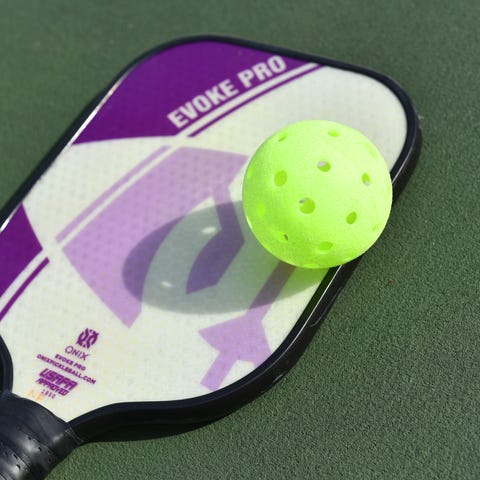 A pickleball paddle and ball 