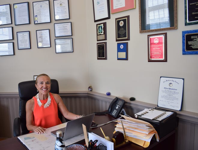 In this file photo, Helena da Silva Hughes, president and CEO of the Immigrants' Assistance Center, sits at her desk.