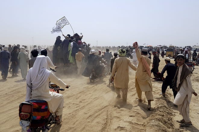 Supporters of the Taliban carry the Taliban's signature white flags in the Afghan-Pakistan border town of Chaman, Pakistan. (AP Photo/Tariq Achkzai)