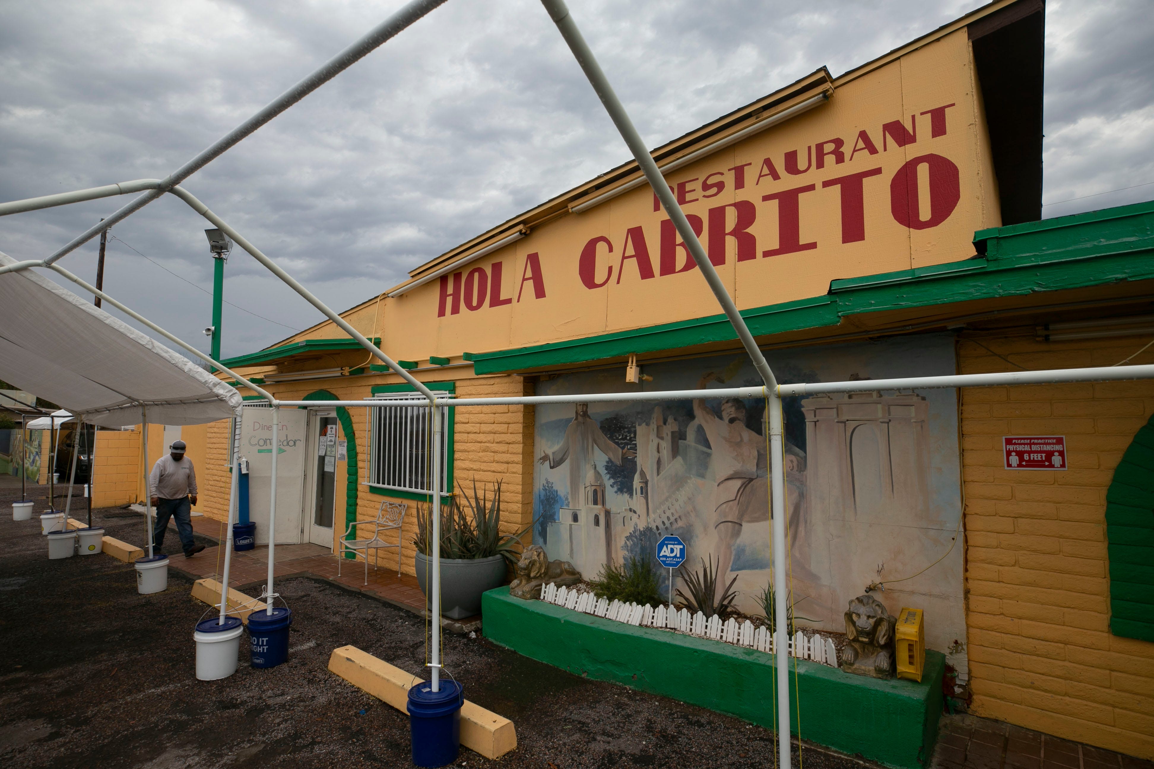 A customer walks into Hola Cabrito restaurant in Phoenix on July 14, 2021. The restaurant specializes in birria de chivo, goat meat with a secret marinade that's stewed for hours.