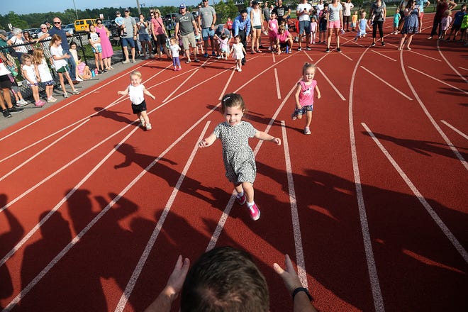 Valerie Gati, of Marshfield, runs into the arms of her dad, Peter, during the 10-meter dash at the youth track meet at the Community Track on Wednesday, July 14, 2021.