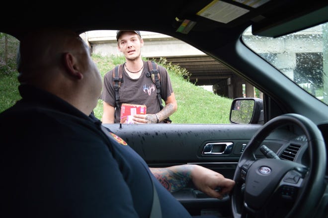 Armando Suarez Del Real of the West Allis Fire Department checks in with Jason, a panhandler in the city. A new social worker position in the City of Wauwatosa would likely do similar follow-ups with residents of Wauwatosa.